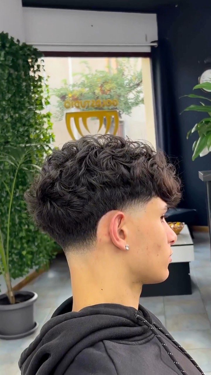 A curly top with a low taper fade