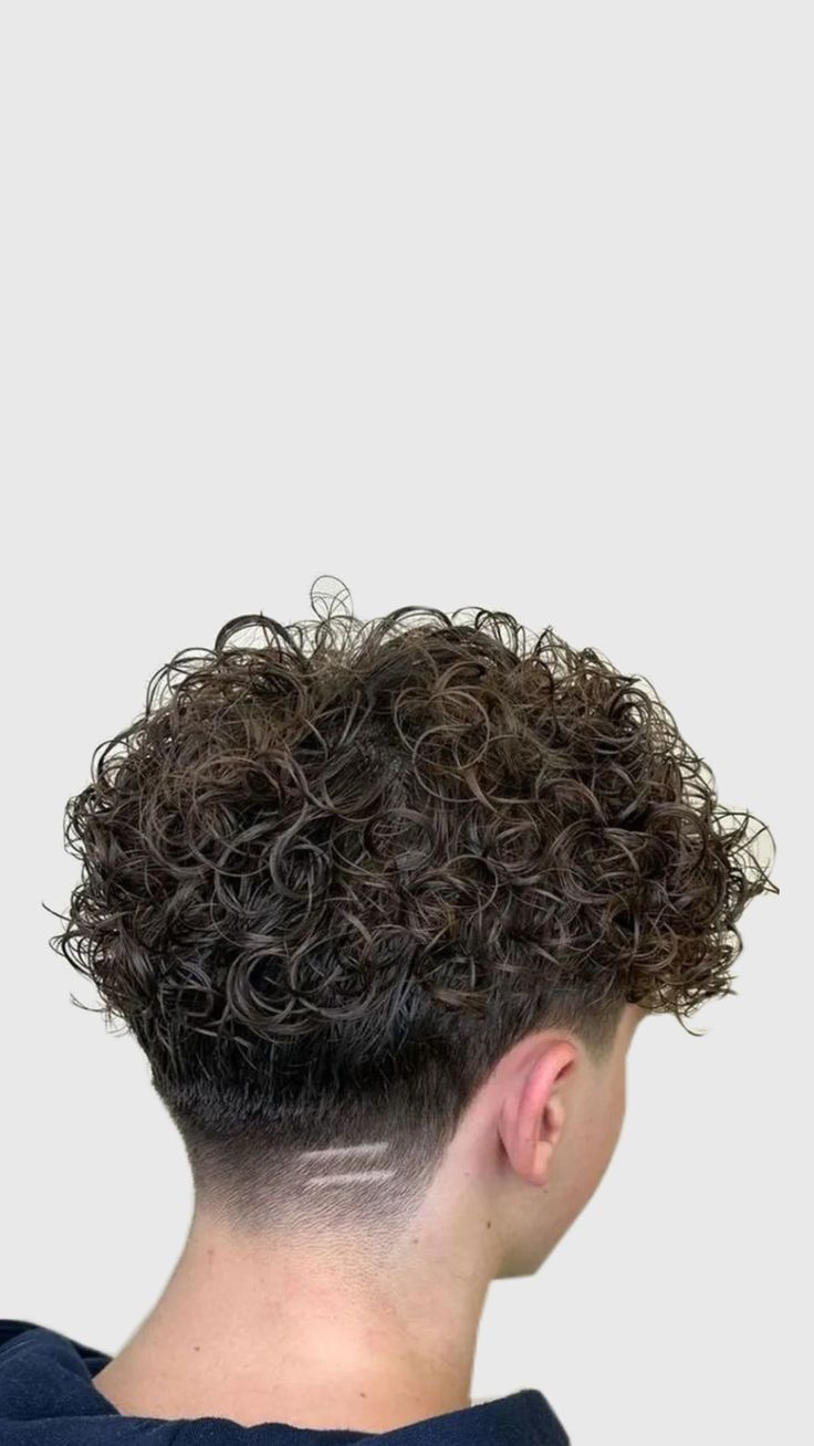 A curly perm with a taper fade and clean neckline