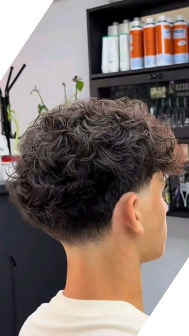 A defined wavy curly top with a clean taper fade