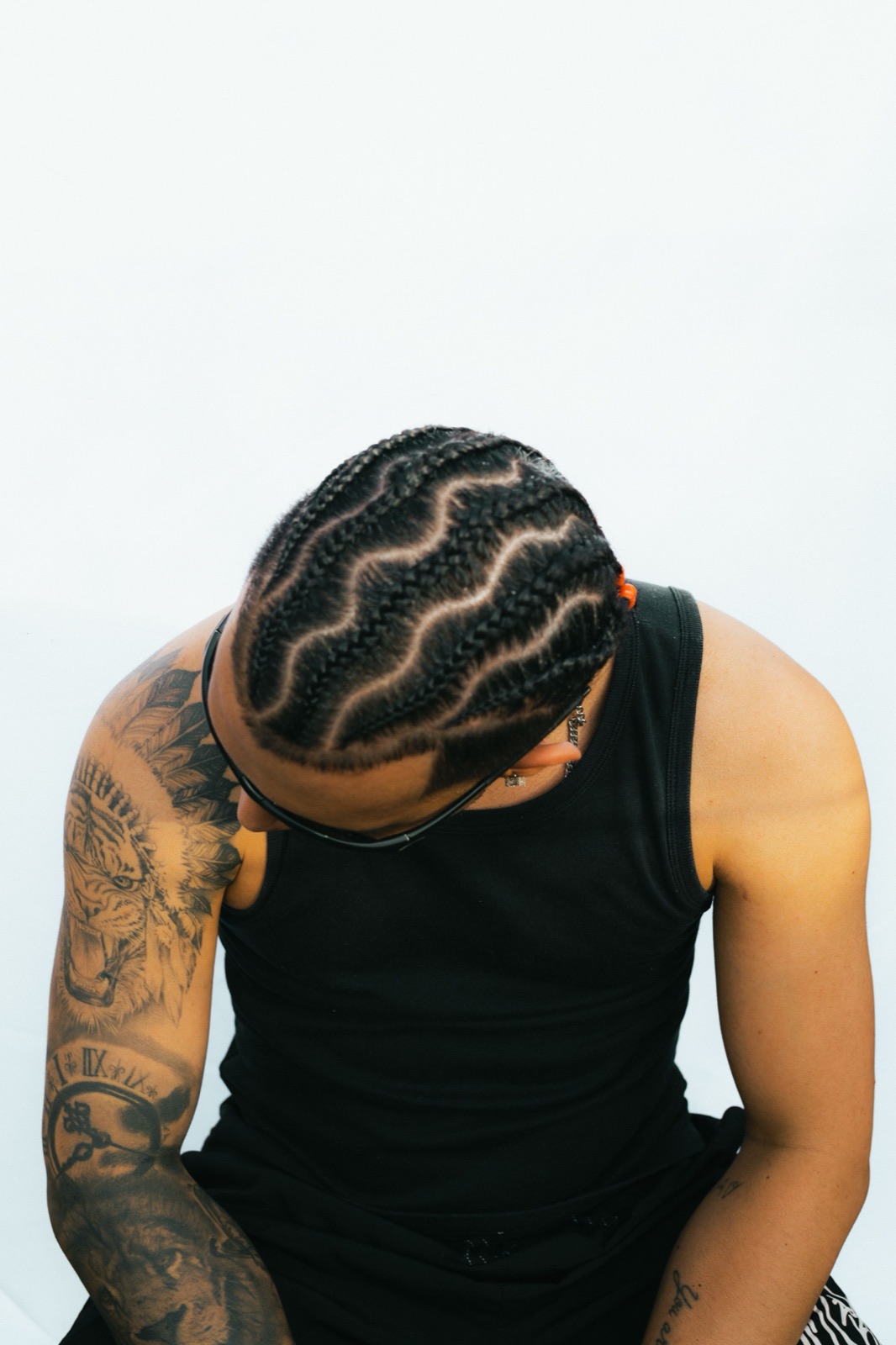 A man with clean cornrows and a carved wave part design