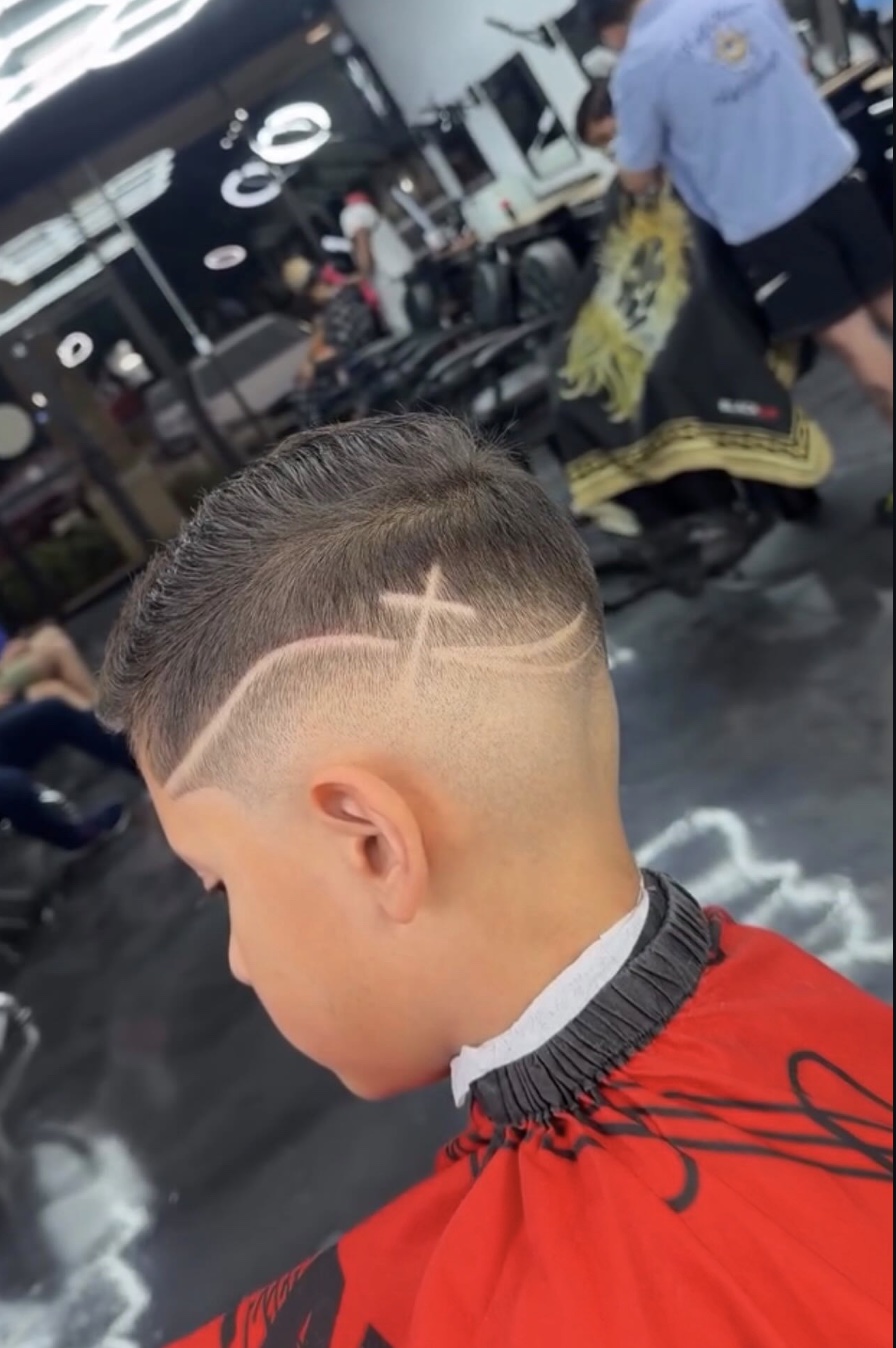 A combover fade with a cross freestyle design