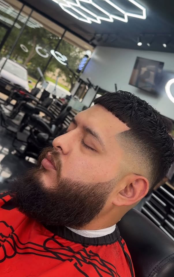 A skin fade and lined beard from the side in the shop