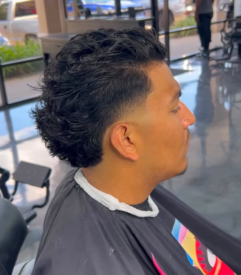 A curly top with a clean low taper fade