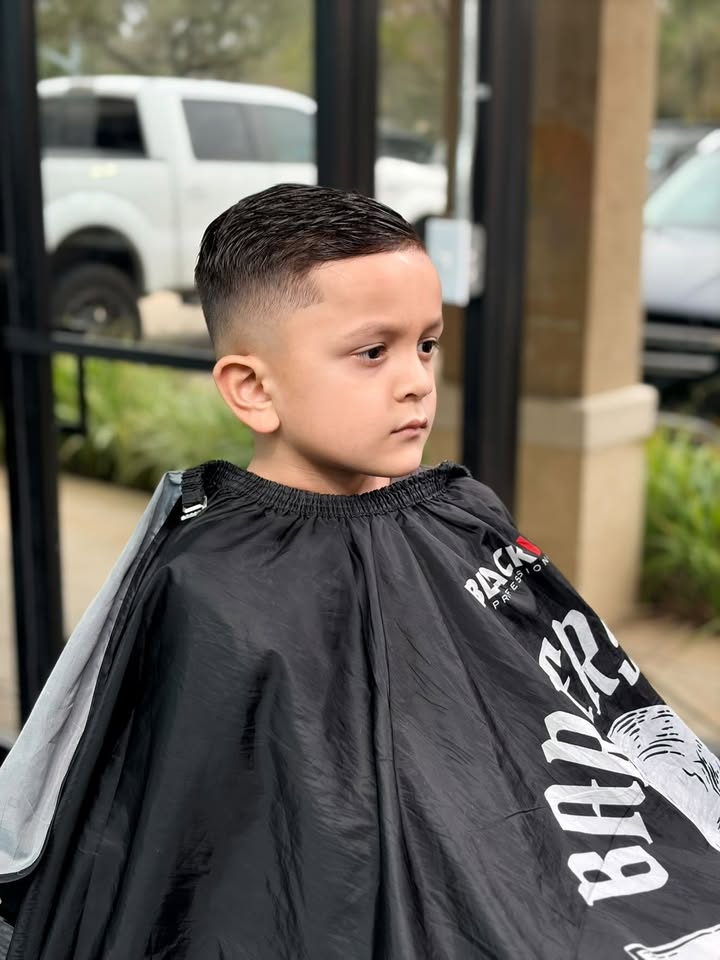 A young client with a clean crop and mid fade