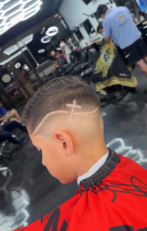 A kids fade with a freestyle X design shaved in